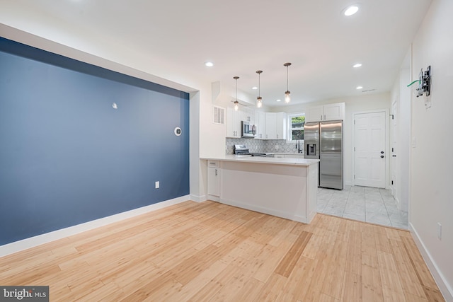 1621 Lyman Pl NE, Washington, DC 20002 - kitchen with stainless steel appliances, a peninsula, white cabinetry, tasteful backsplash, and recessed lighting