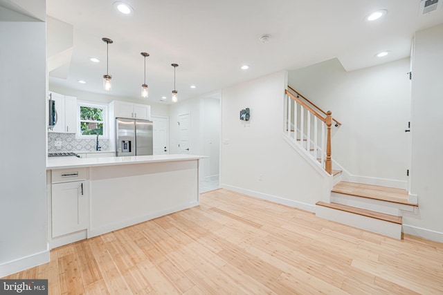 1621 Lyman Pl NE, Washington, DC 20002 - kitchen featuring appliances with stainless steel finishes, light wood-style floors, a peninsula, white cabinets, and light countertops