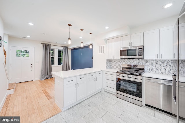1621 Lyman Pl NE, Washington, DC 20002 - kitchen featuring stainless steel appliances, a peninsula, light countertops, decorative backsplash, and white cabinetry
