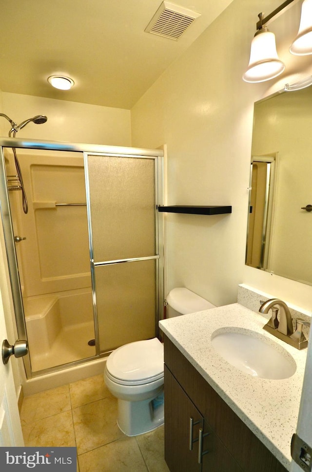 full bathroom featuring vanity, a shower stall, toilet, and visible vents