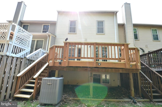 rear view of property with central AC unit, a wooden deck, and stairway
