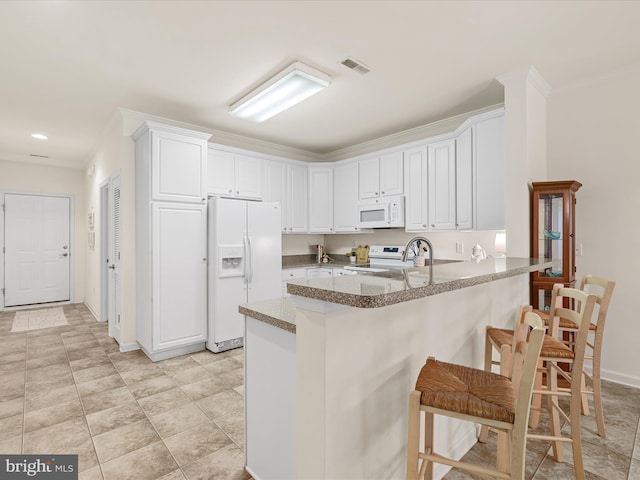 30413 Cedar Neck Rd Unit 304, Ocean View, DE 19970 - kitchen featuring white appliances, ornamental molding, a peninsula, white cabinets, and a breakfast bar