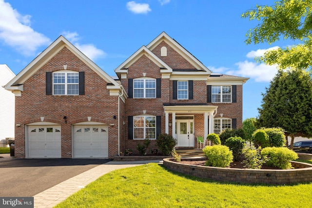 323 Palton Rd, Bensalem, PA 19020 - colonial-style house with asphalt driveway, an attached garage, brick siding, and a front lawn