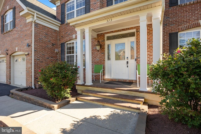 323 Palton Rd, Bensalem, PA 19020 - doorway to property featuring brick siding, an attached garage, and a porch