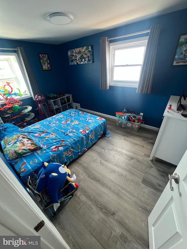bedroom with baseboards and wood finished floors