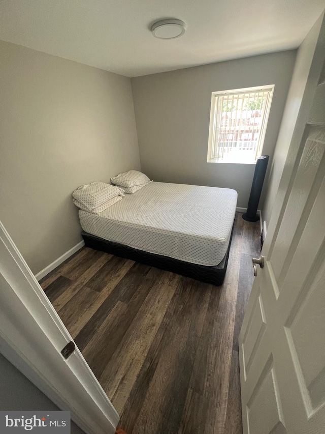 bedroom featuring baseboards and wood finished floors