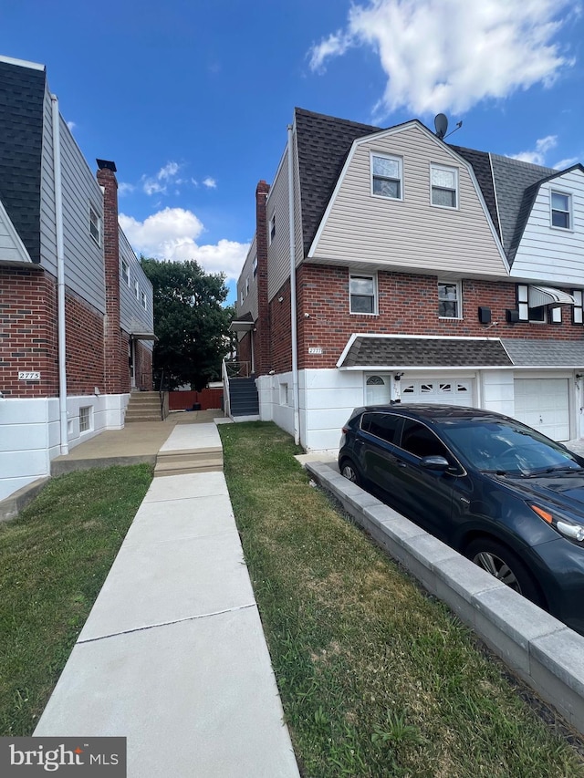 view of home's exterior with a lawn, brick siding, an attached garage, and a shingled roof