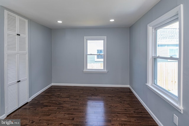 spare room with dark wood-type flooring, recessed lighting, and baseboards