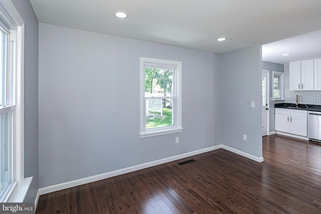 interior space featuring a sink, recessed lighting, baseboards, visible vents, and dark wood-style floors