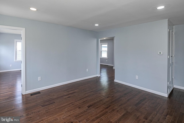 spare room with visible vents, recessed lighting, baseboards, and dark wood-type flooring