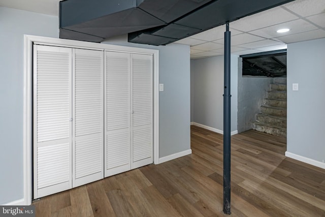 finished basement featuring baseboards, stairs, and wood finished floors