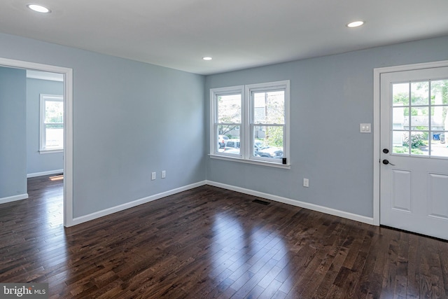 foyer entrance with dark wood-style flooring, baseboards, and a healthy amount of sunlight