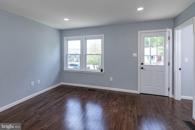 foyer entrance featuring dark wood-style flooring, baseboards, visible vents, and recessed lighting
