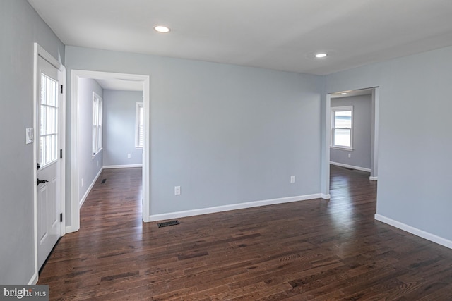 empty room featuring recessed lighting, baseboards, visible vents, and dark wood-type flooring
