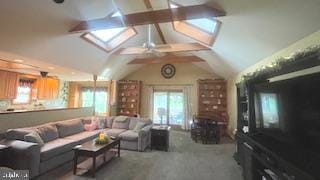 carpeted living area with a skylight, vaulted ceiling, and ceiling fan