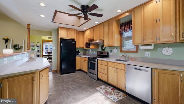 kitchen featuring stainless steel appliances, a sink, under cabinet range hood, light countertops, and ceiling fan