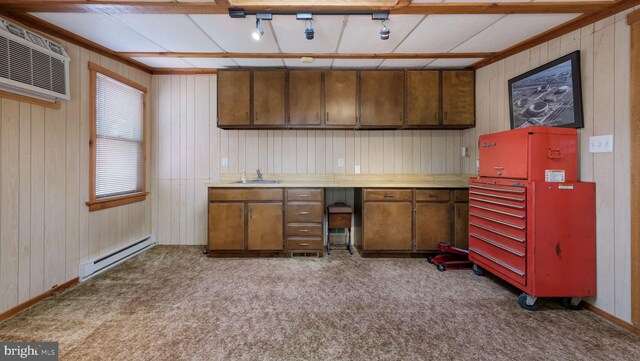 kitchen with baseboard heating, a sink, carpet flooring, brown cabinets, and light countertops