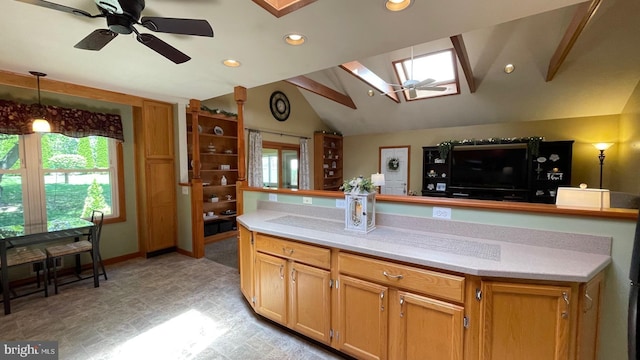 kitchen with a skylight, vaulted ceiling, ceiling fan, plenty of natural light, and recessed lighting