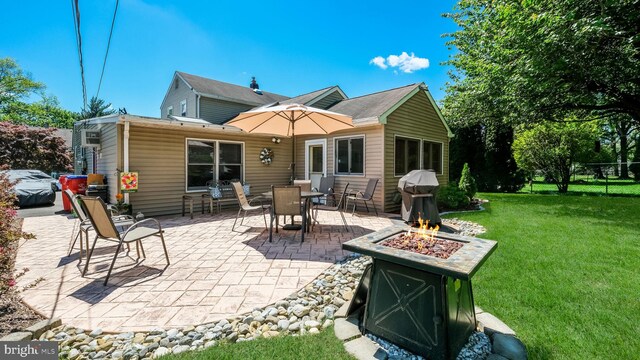 back of house with a fire pit and a patio area