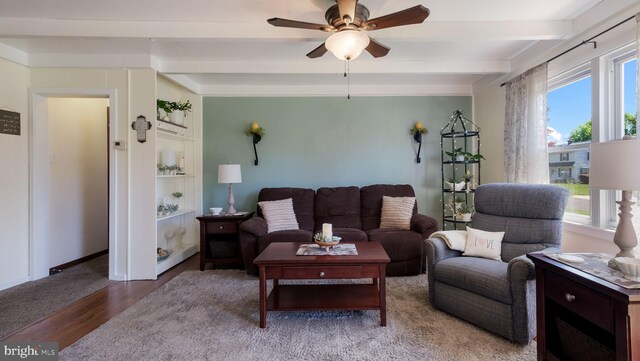 living room featuring a ceiling fan, wood finished floors, and beamed ceiling