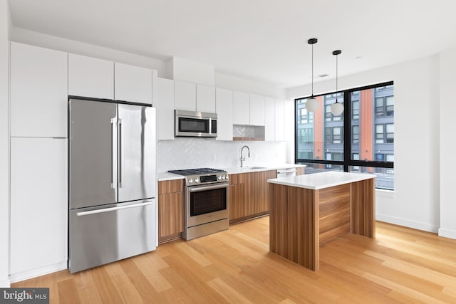 7175 12th St NW Unit 506, Washington, DC 20011 - kitchen with modern cabinets, a center island, a sink, light wood finished floors, and appliances with stainless steel finishes