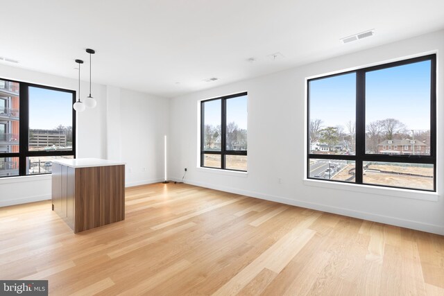 7175 12th St NW Unit 506, Washington, DC 20011 - unfurnished living room featuring visible vents, light wood finished floors, and baseboards