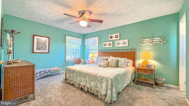 carpeted bedroom featuring baseboards, ceiling fan, and a textured ceiling