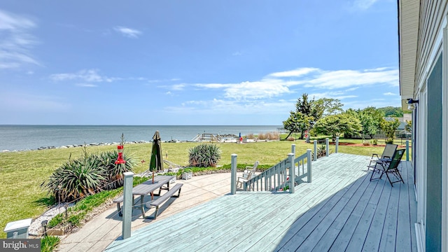 wooden terrace with a water view and a yard
