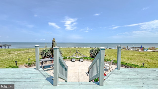 wooden deck featuring a lawn and a water view