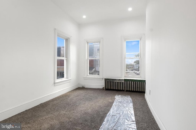 unfurnished room with carpet floors, recessed lighting, baseboards, and radiator heating unit