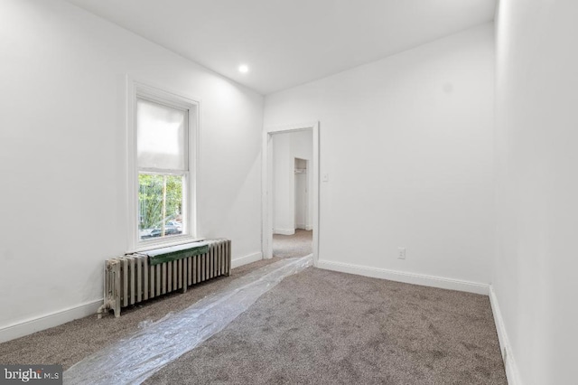 empty room with baseboards, carpet flooring, radiator heating unit, and recessed lighting