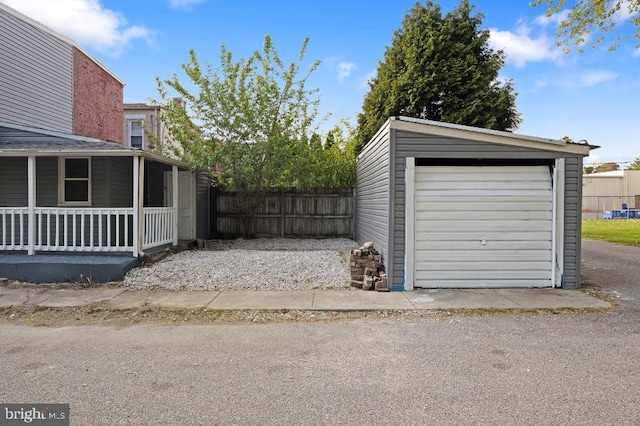 garage with covered porch and fence