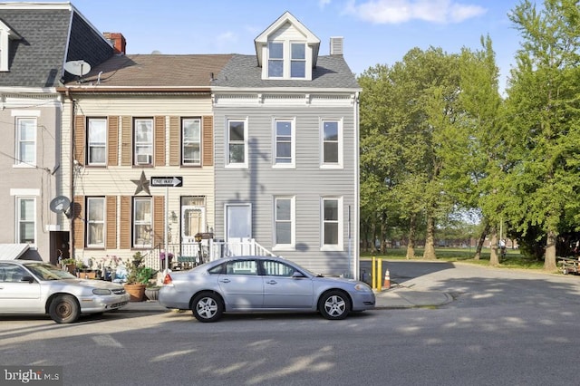 townhome / multi-family property with a chimney and cooling unit