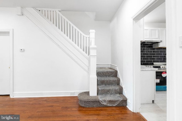 stairs featuring baseboards and wood finished floors