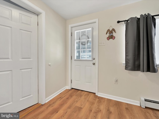 24 W Garibaldi Ave, Nesquehoning, PA 18240 - doorway to outside with baseboards, a baseboard radiator, and light wood-style flooring