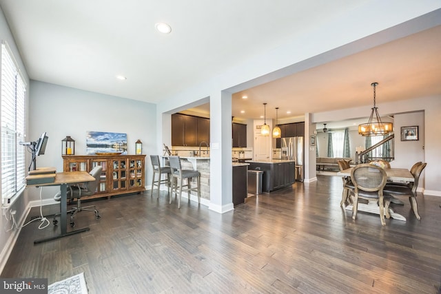 dining room featuring dark wood-style flooring, a notable chandelier, recessed lighting, and plenty of natural light