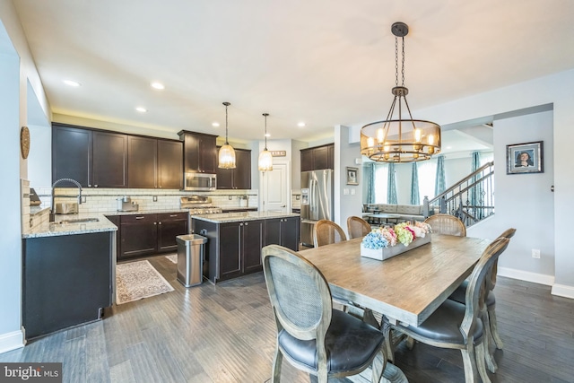 dining area featuring recessed lighting, stairs, dark wood-style floors, and a notable chandelier