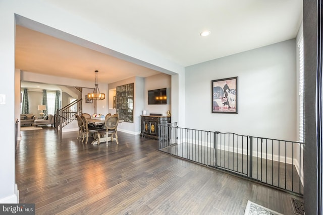 dining room featuring stairs, wood finished floors, recessed lighting, an inviting chandelier, and baseboards