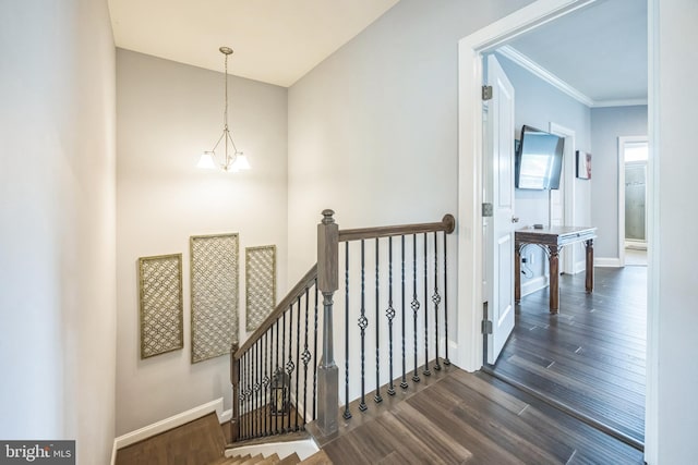 stairway featuring crown molding, baseboards, and wood finished floors