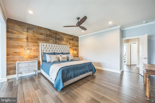 bedroom with baseboards, ornamental molding, visible vents, wooden walls, and wood finished floors