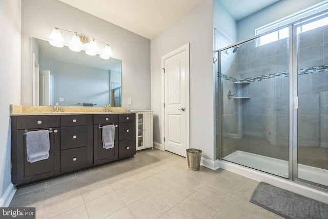 bathroom featuring tile patterned flooring, baseboards, a shower stall, and vanity