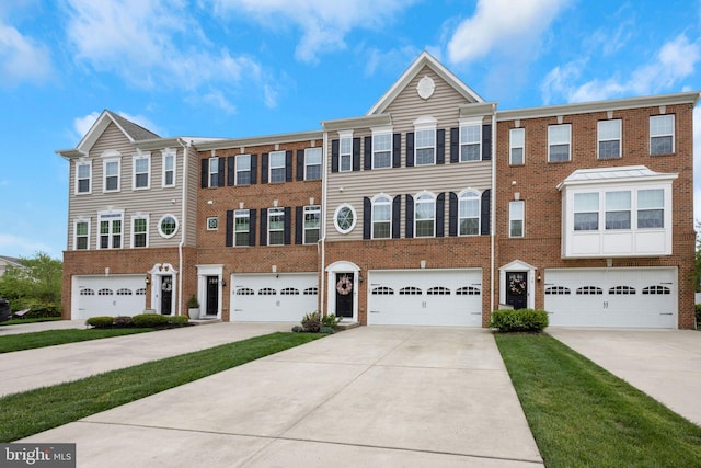 multi unit property featuring a garage, brick siding, and driveway