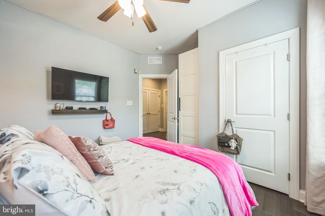 bedroom with visible vents, a ceiling fan, and dark wood-style floors