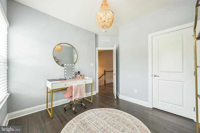 office space with baseboards, an inviting chandelier, visible vents, and wood finished floors