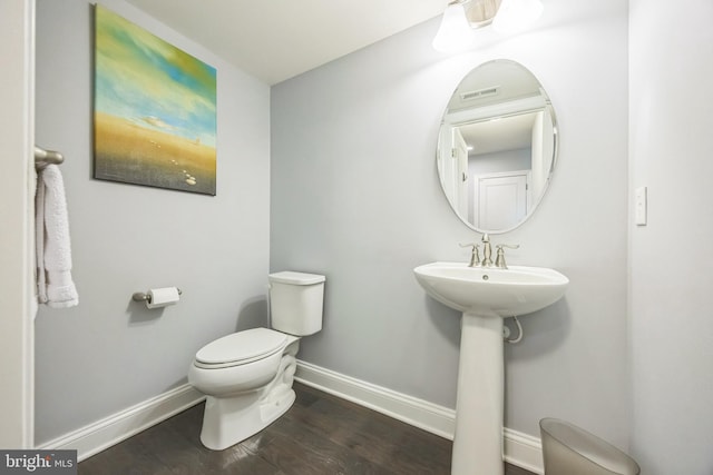 bathroom featuring baseboards, visible vents, toilet, and wood finished floors