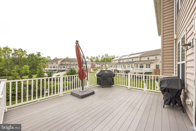 wooden terrace with a grill and a residential view