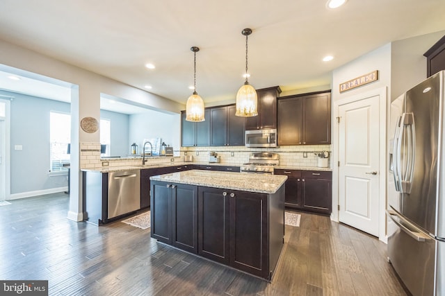 kitchen with appliances with stainless steel finishes, decorative backsplash, dark brown cabinets, and a sink