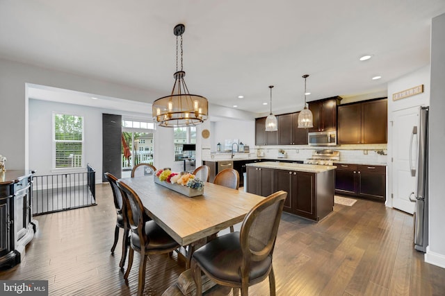 dining area with dark wood-style flooring, recessed lighting, and an inviting chandelier
