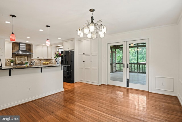 1716 Saddle Ridge Ct, Vienna, VA 22182 - kitchen featuring wall chimney exhaust hood, black fridge, dark countertops, decorative backsplash, and white cabinets