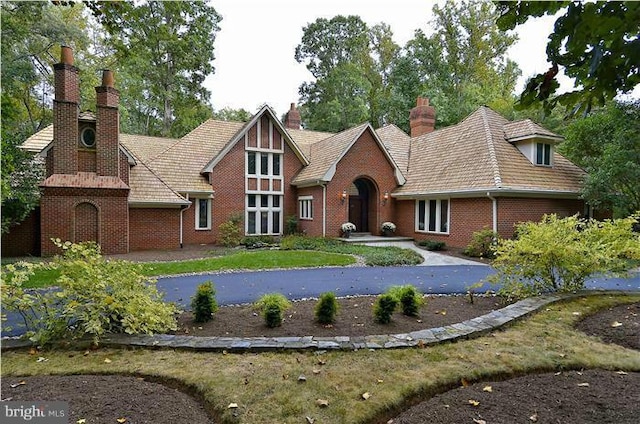 tudor-style house with brick siding and a chimney